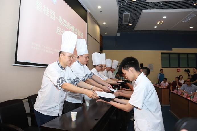 说明: D:\2019年新闻\5月16日 “碧桂园-粤菜师傅培训”首期培训班在我校正式开班\拜师仪式.png